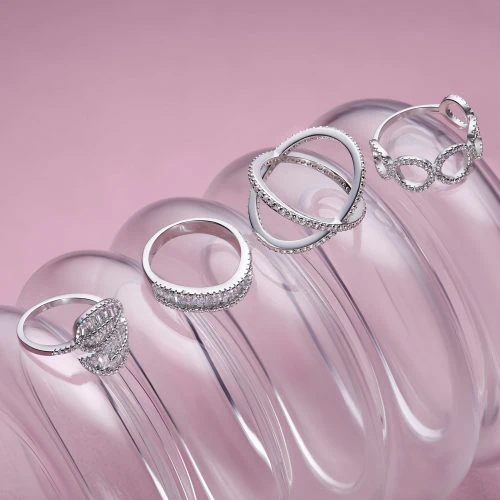 חבילת טבעות כסף על רקע ורוד מצולמת בסטודיו לצילום לייף-סטייל ומדגישה את הקסם שבצילום תכשיטים למדיה חברתית