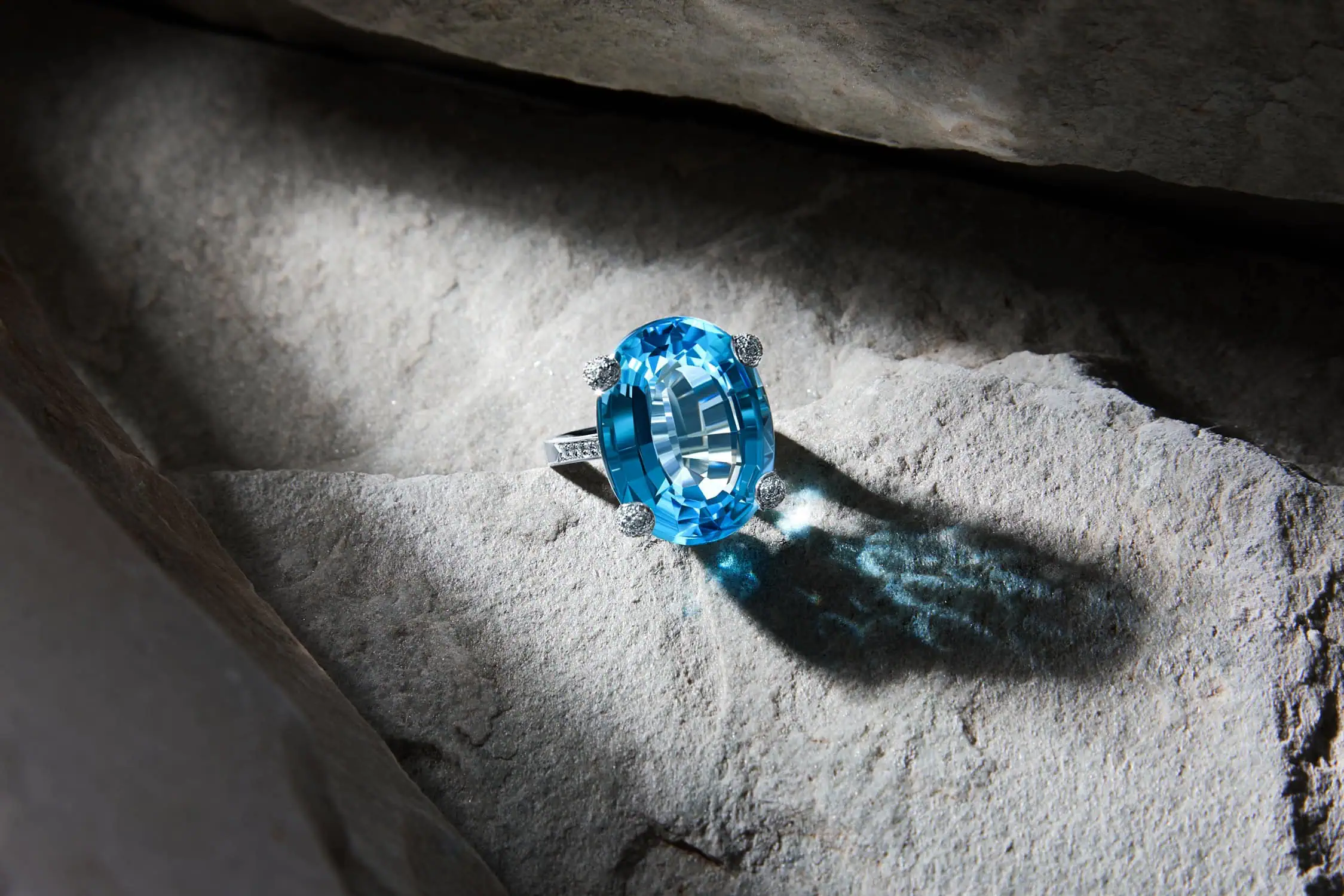 טבעת כסף עם אבן כחולה אובלית בהירה מצולמת כחלק מתהליך צילום תכשיטים מחיר