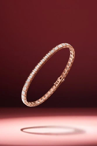 צמיד מזהב ורוד מרחף, מואר באור דרמטי על רקע אדום עשיר, יוצר סצנה יוקרתית בצילום יהלומים