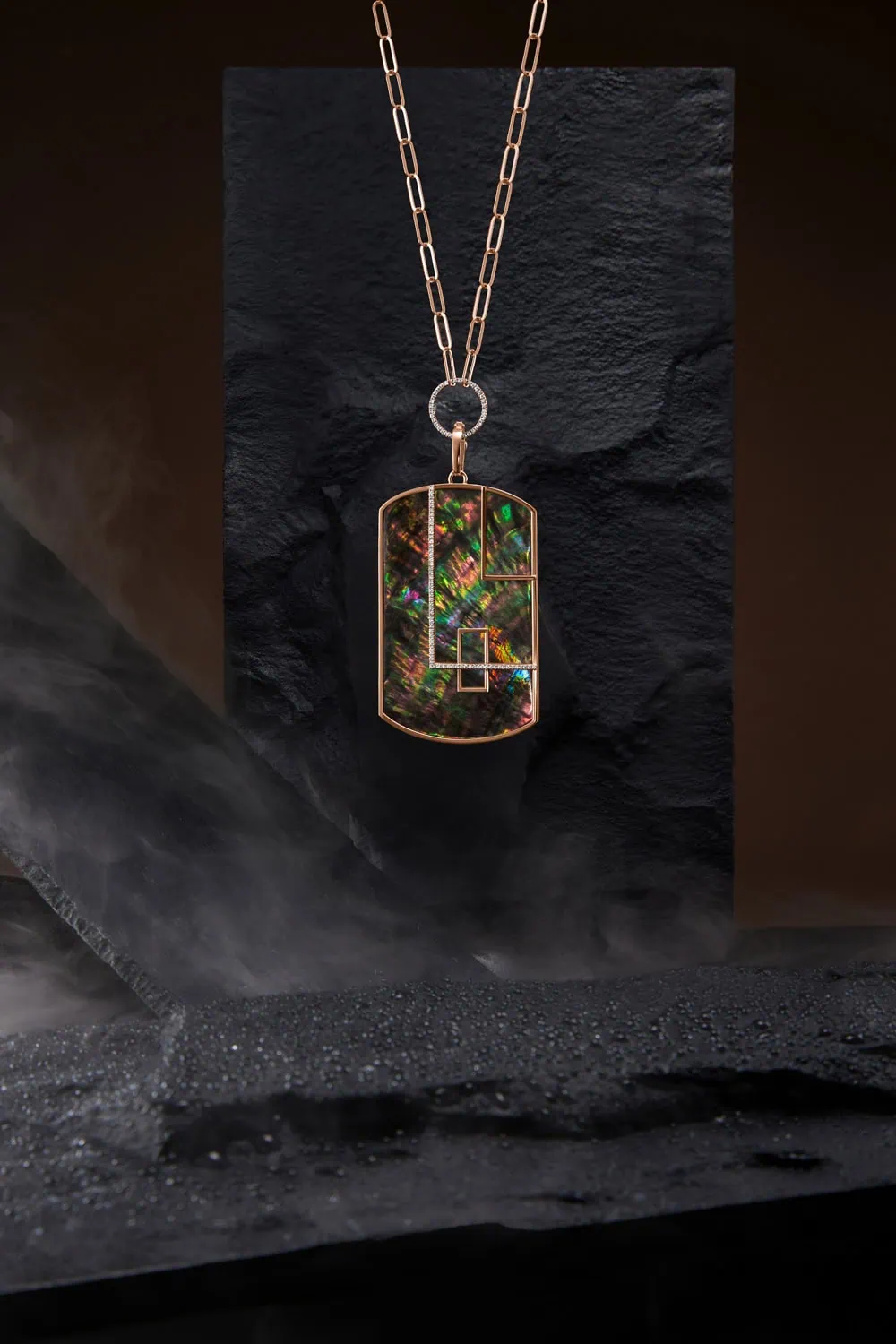 תליון פנינה כהה על שרשרת זהב מוצג בצילום מוצר בסגנון לייף-סטייל שמביא לידי ביטוי את הקסם שבצילום תכשיטים